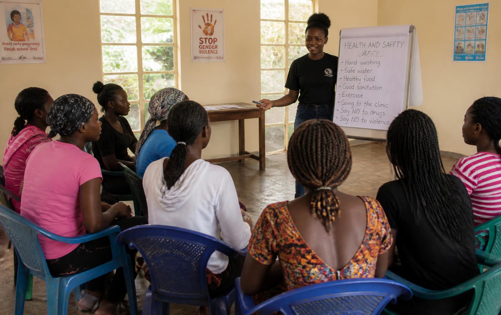 Young women taking part in a community health and safety workshop led by a facilitator